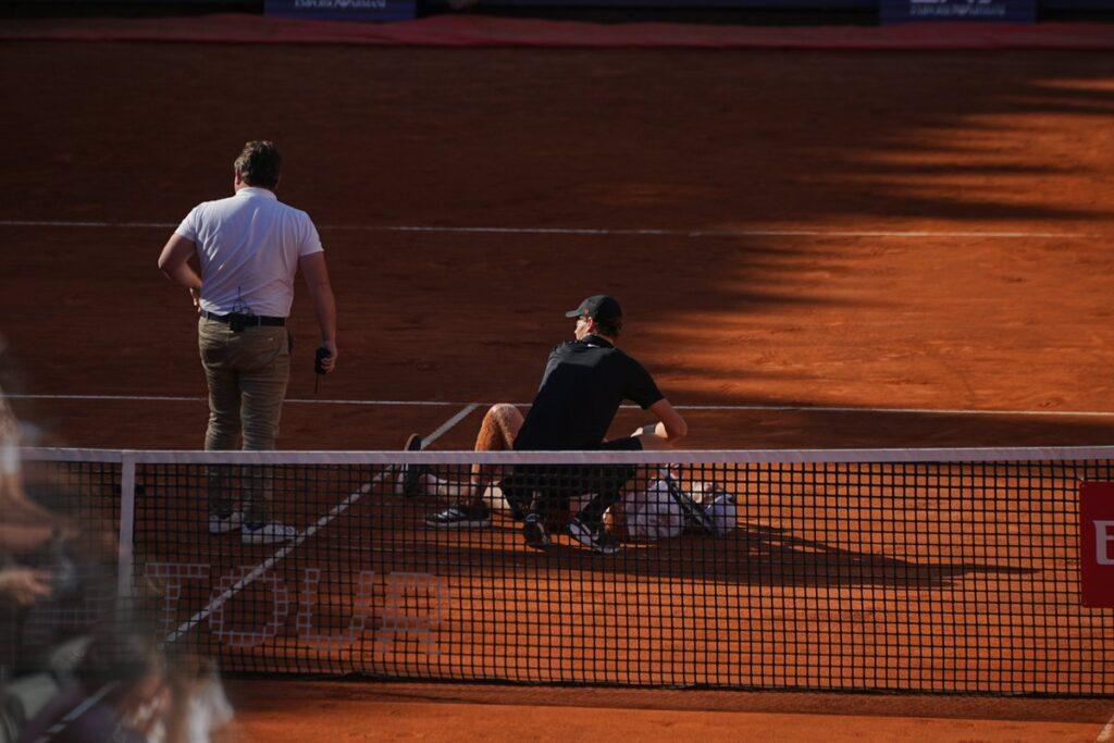 La foto del match: Sinner va in soccorso di De Jong dopo una rovinosa caduta dell'olandese