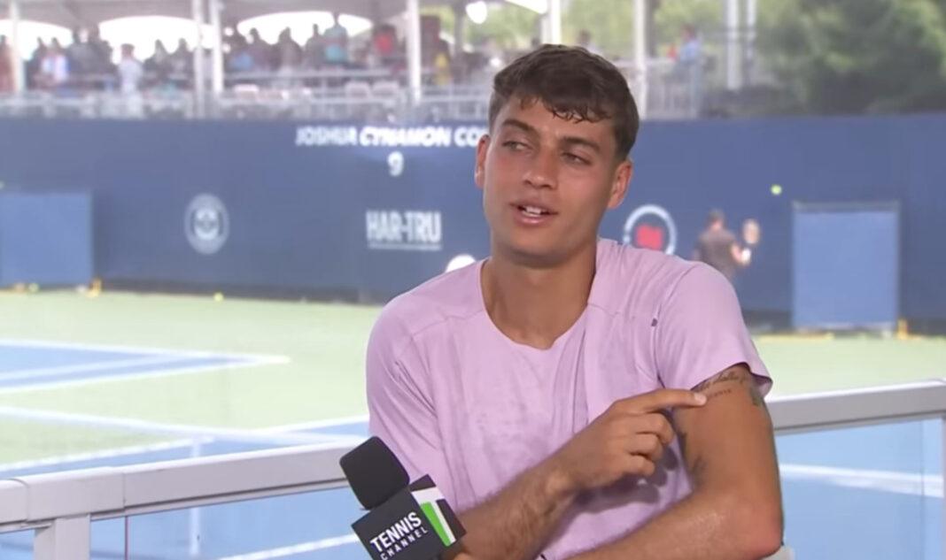Cobolli indica i suoi nuovi tatuaggi (foto presa sa youtube tennischannel)