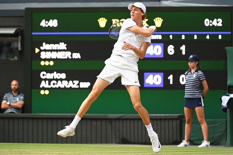 Sinner con dietro tabellone punteggio WImbledon (foto presa da Ansa)